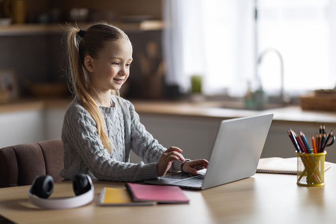 Cute Little Girl Using Laptop At Home