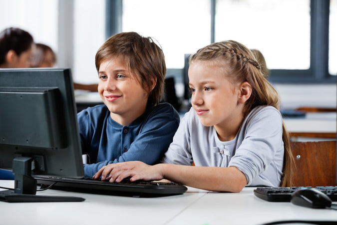 summer coding camps - Little-Boy-And-Girl-Using-Desktop-PC-At-Desk-In-School-Computer-Lab